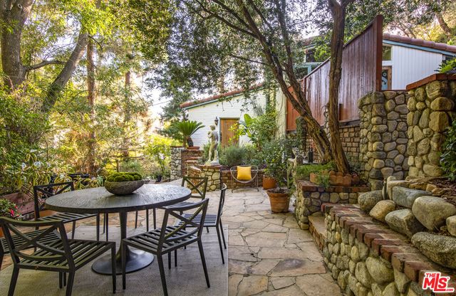 a patio with table and chairs and potted plants