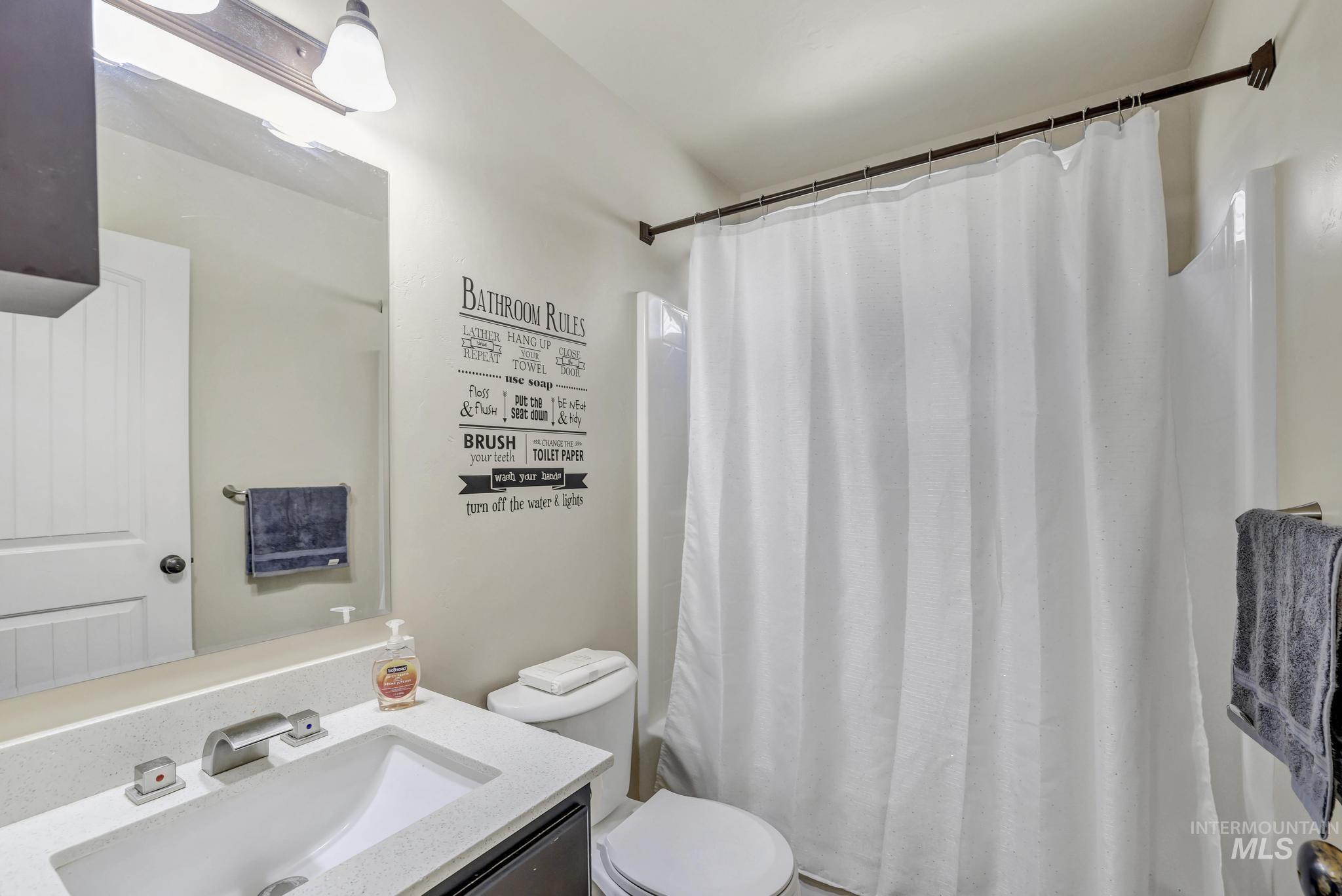 446 Noble Street Twin Falls, ID 83301 - Photo 14 of 42 Bathroom featuring a vanity with an integrated rectangular sink, a light-colored countertop, and a brushed nickel faucet