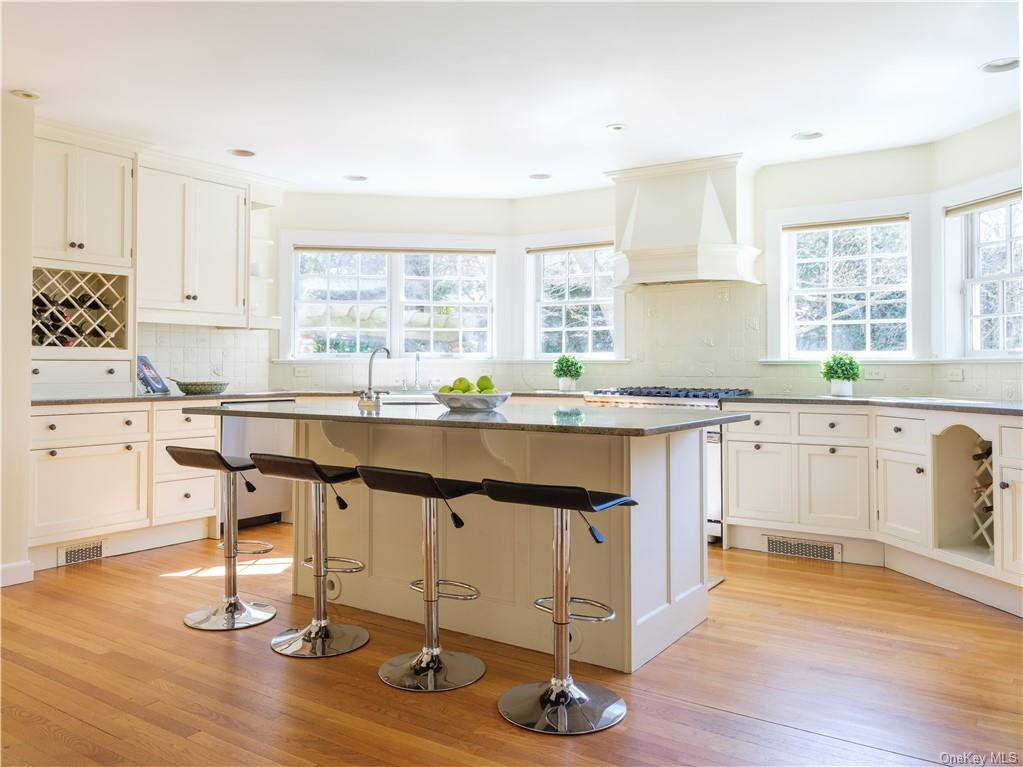 a kitchen with granite countertop a sink cabinets and wooden floor
