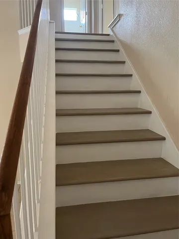 an empty room with a chandelier fan and windows