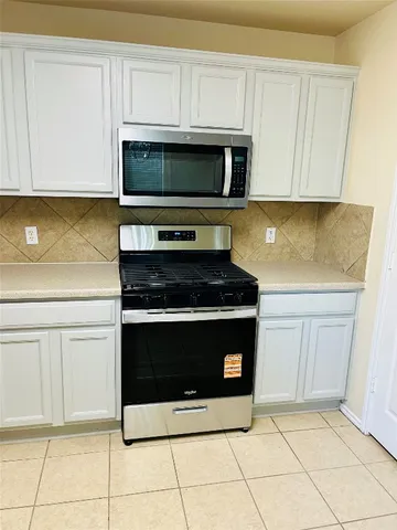 a kitchen with stainless steel appliances granite countertop a stove a microwave and a sink
