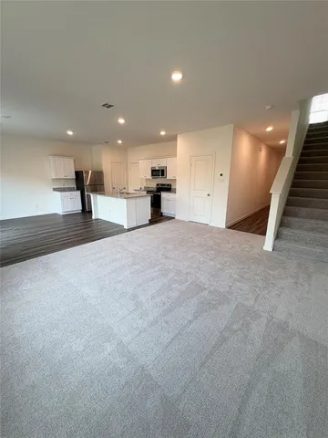 a kitchen with granite countertop a stove a sink and a refrigerator