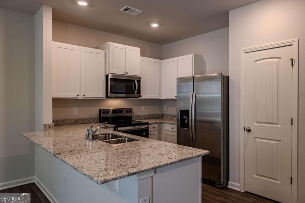 23 Sweetspire Drive Northwest Rome, GA 30165 - Photo 14 of 23 a kitchen with kitchen island granite countertop stainless steel appliances and a counter space