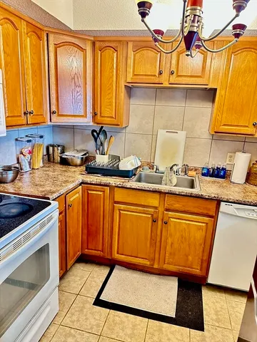 a kitchen with stainless steel appliances granite countertop wooden cabinets a stove a sink and dishwasher