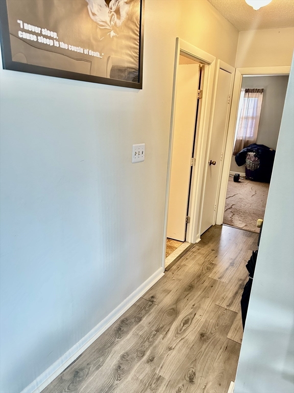 118 Oak Lane, Unit 10 Brockton, MA 02301 - Photo 6 of 6 a view of a hallway with wooden floor and staircase