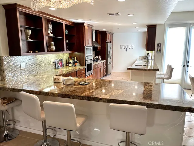 a kitchen with granite countertop a stove and white cabinets