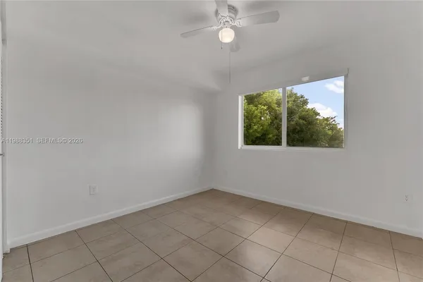 an empty room with a window and a fan