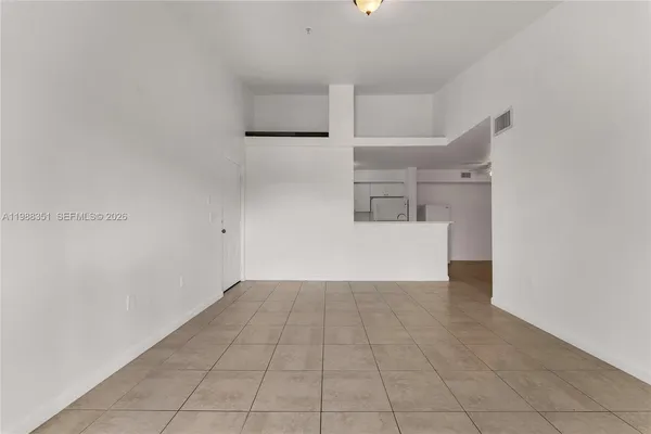 a view of a kitchen with refrigerator and white cabinets