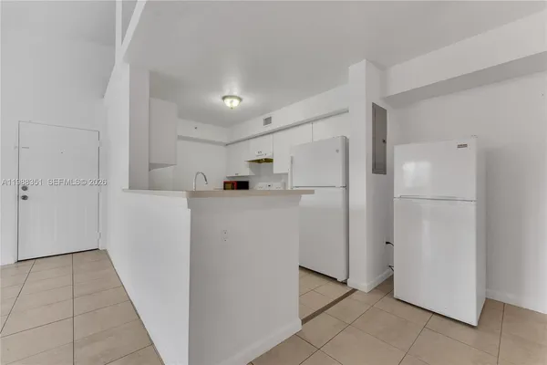 a kitchen with a sink dishwasher and white cabinets
