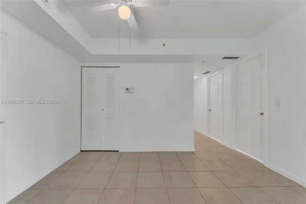 an empty room with a ceiling fan and window
