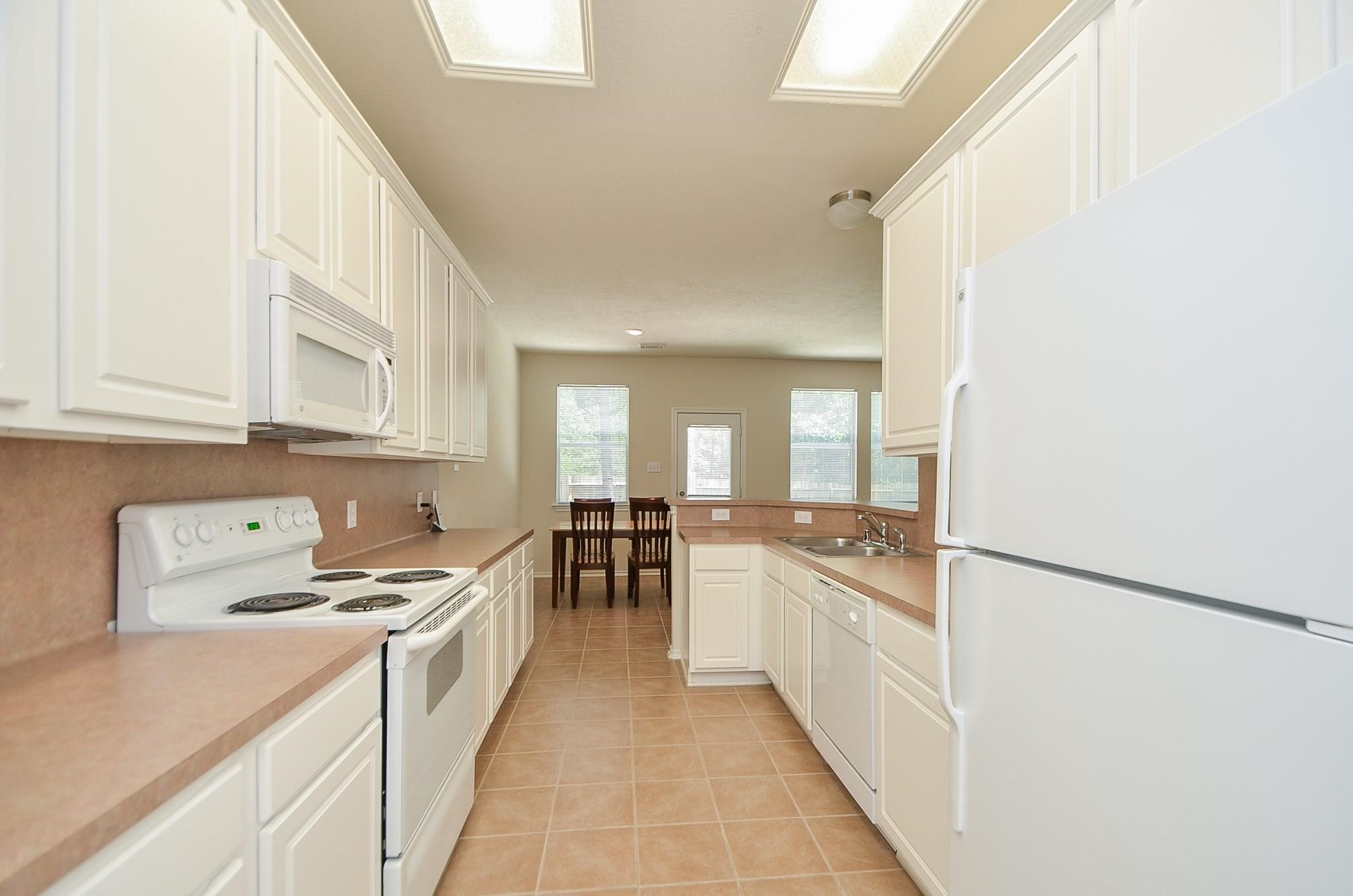 46 East Stedhill Loop Conroe, TX 77384 - Photo 14 of 32 a kitchen with granite countertop a sink and cabinets