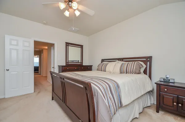 a spacious bedroom with a bed and a chandelier
