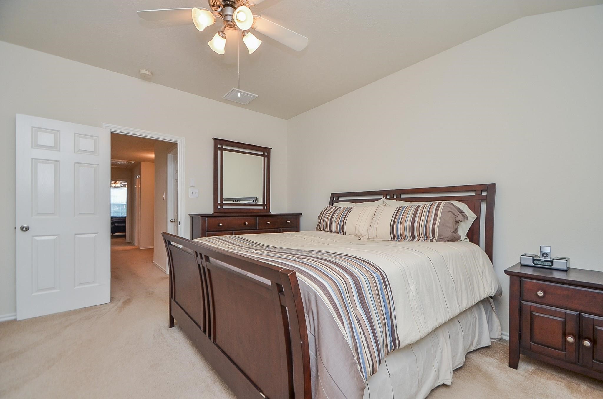 46 East Stedhill Loop Conroe, TX 77384 - Photo 17 of 32 a spacious bedroom with a bed and a chandelier