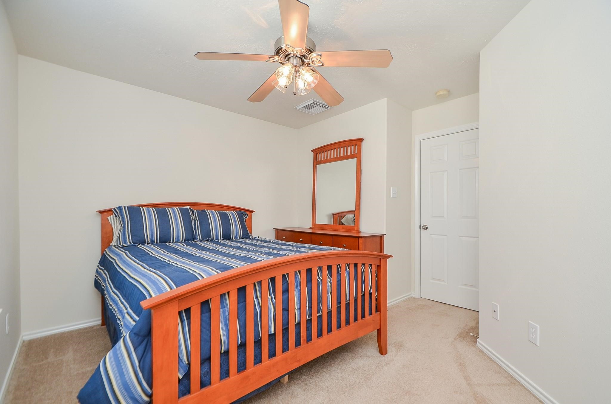 46 East Stedhill Loop Conroe, TX 77384 - Photo 24 of 32 a bedroom with a bed and a chandelier