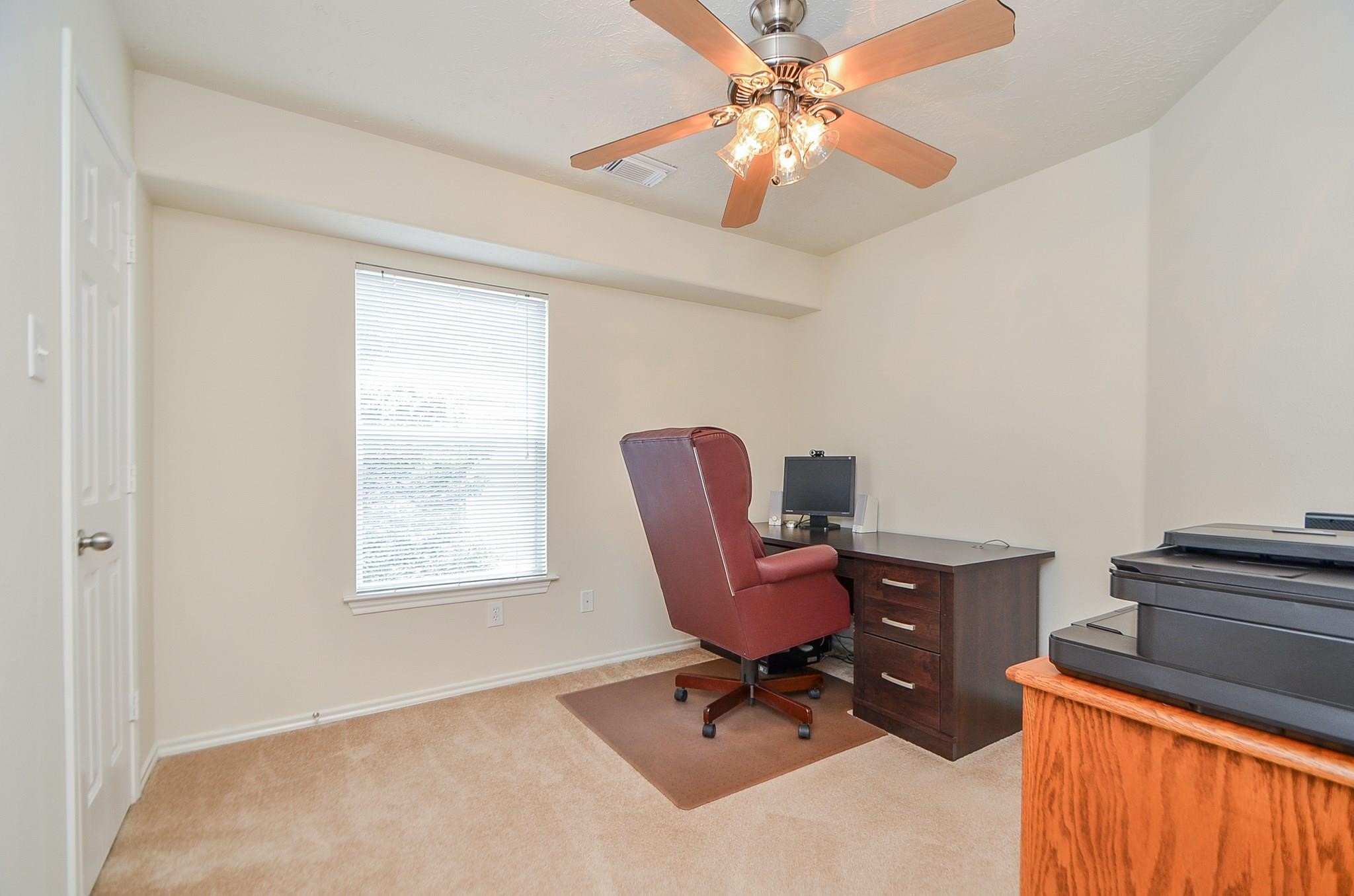 46 East Stedhill Loop Conroe, TX 77384 - Photo 25 of 32 a workspace with chandelier fan and a window
