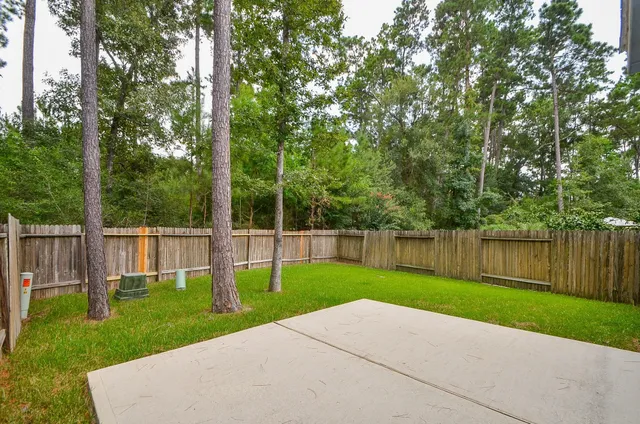 a view of a park with large trees and a barn in it