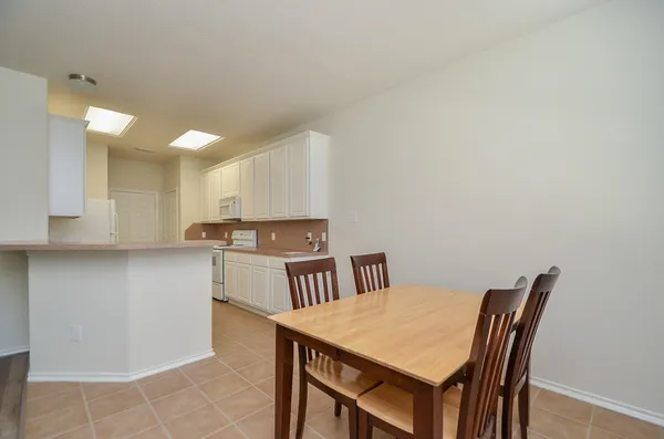 a kitchen with a table chairs refrigerator and cabinets