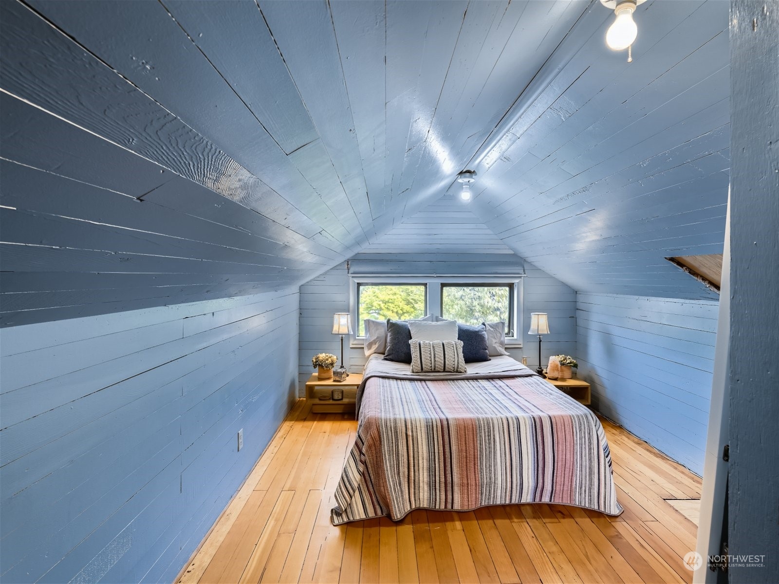 3032 Walnut Avenue Southwest Seattle, WA 98116 - Photo 16 of 29 a bedroom with a bed and wooden floor