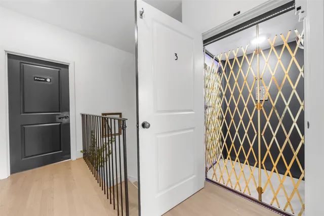 a walk in closet with wooden floor