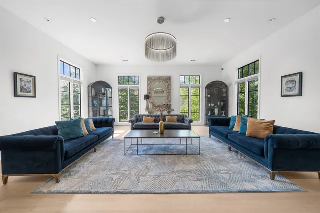 a living room with furniture a large window and a chandelier