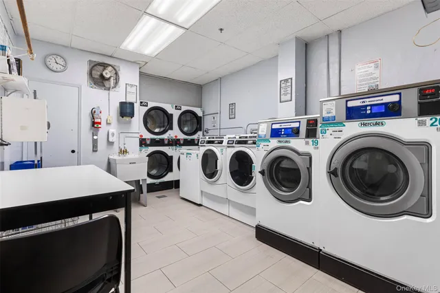 a utility room with dryer washer and a view of living room