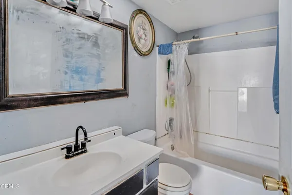 a bathroom with a granite countertop sink a toilet and a shower