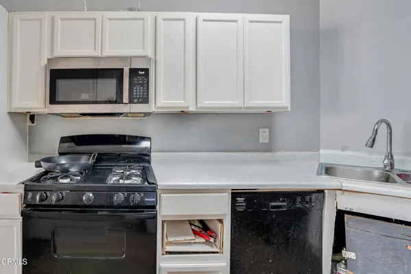 a kitchen with stainless steel appliances granite countertop a stove and a microwave
