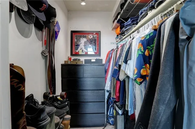 a view of walk in closet with clothes and shoes
