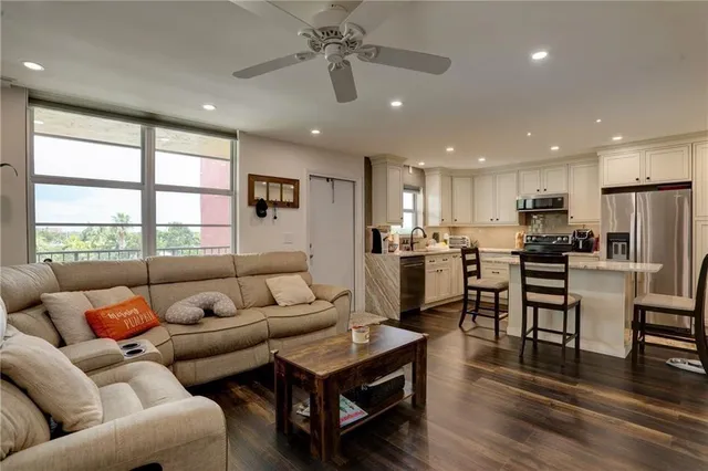 a living room kitchen with furniture and a large window
