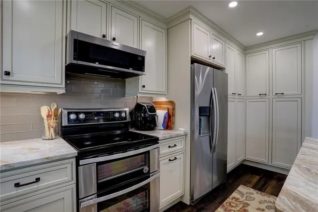 a kitchen with stainless steel appliances a stove a microwave and a refrigerator