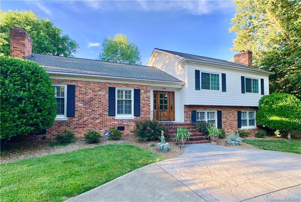 a front view of a house with a yard and potted plants