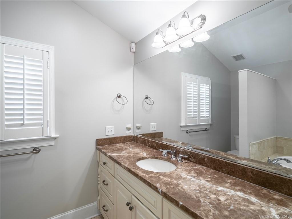 3200 Wickersham Road Charlotte, NC 28211 - Photo 16 of 40 a bathroom with a granite countertop sink a large mirror and a window