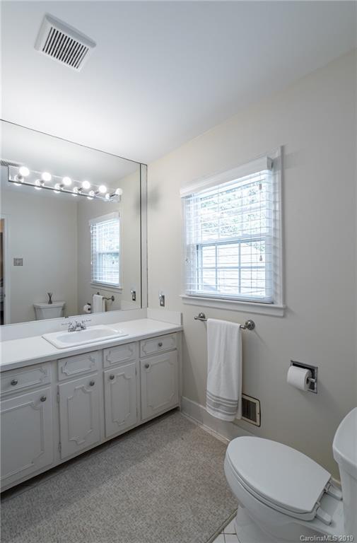 3200 Wickersham Road Charlotte, NC 28211 - Photo 27 of 40 a bathroom with a toilet a sink a mirror a window and vanity