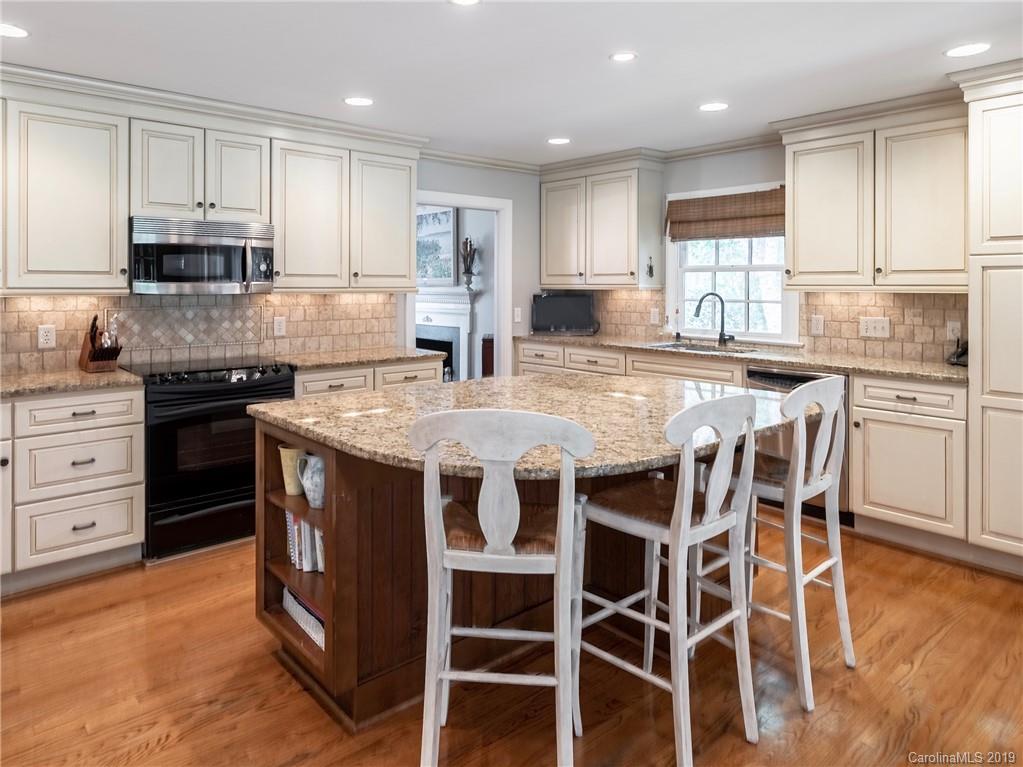 3200 Wickersham Road Charlotte, NC 28211 - Photo 5 of 40 a kitchen with stainless steel appliances granite countertop a stove top oven a sink a counter space and cabinets