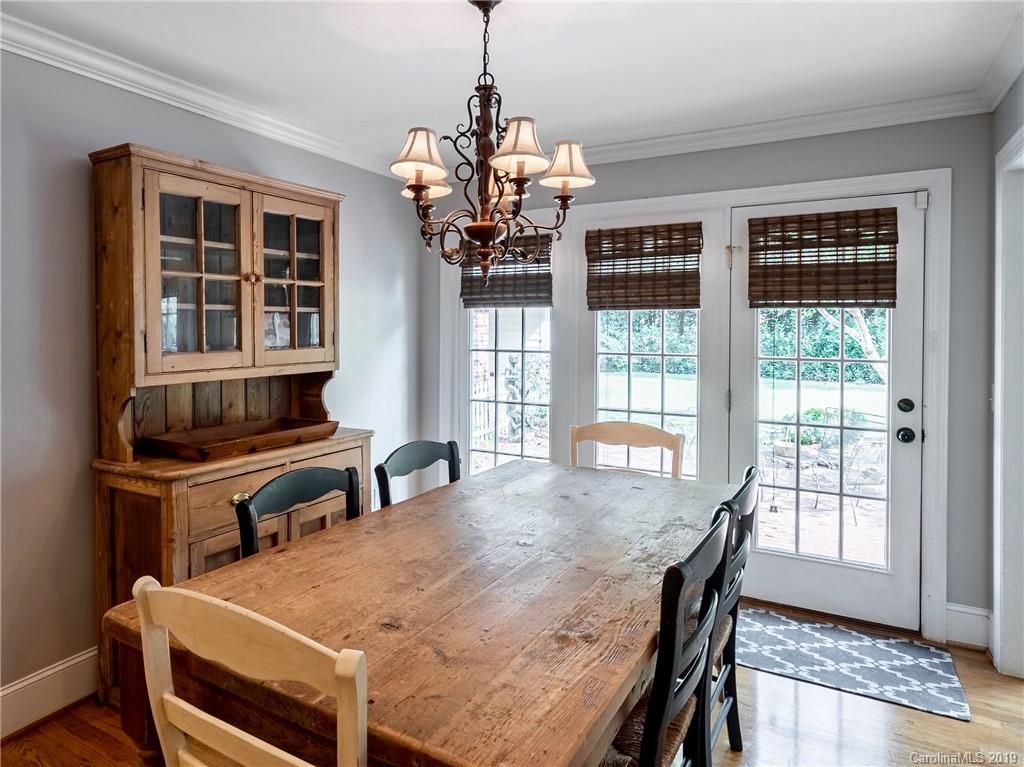 3200 Wickersham Road Charlotte, NC 28211 - Photo 7 of 40 a dining room with wooden floor a chandelier a wooden table and chairs