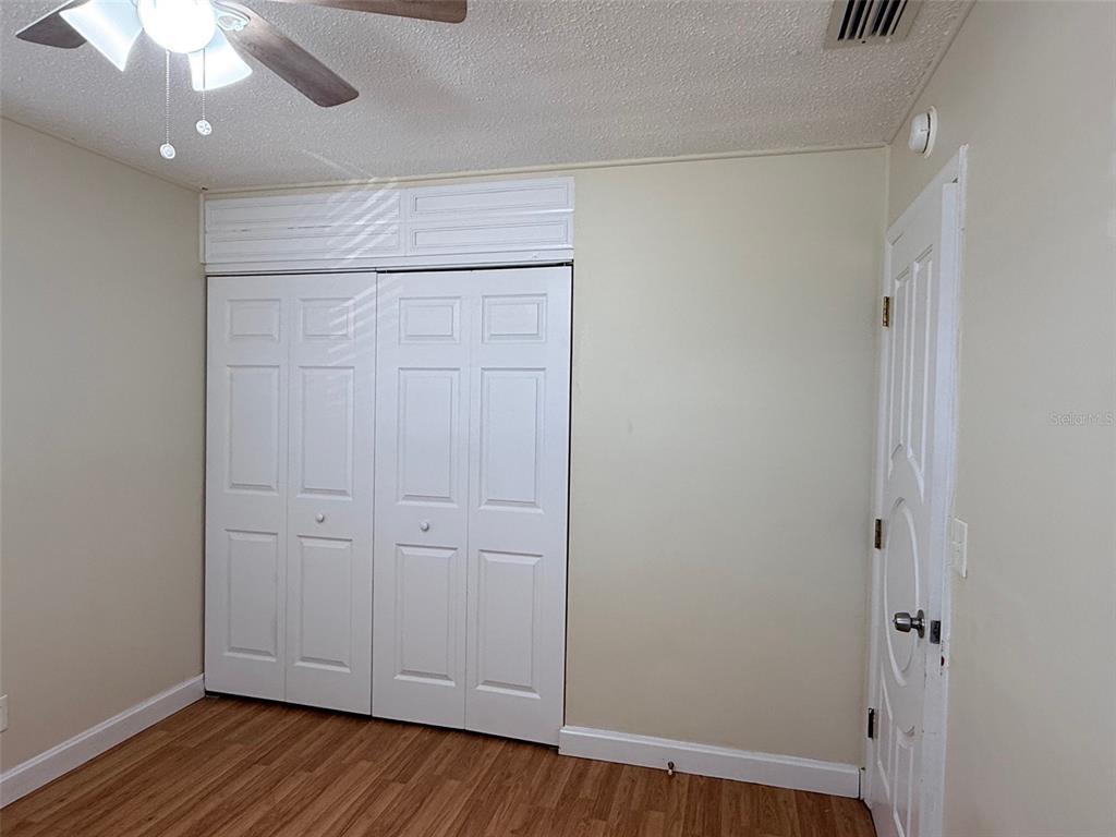 3704 36th Street West Bradenton, FL 34205 - Photo 16 of 34 an empty room with wooden floor and fan