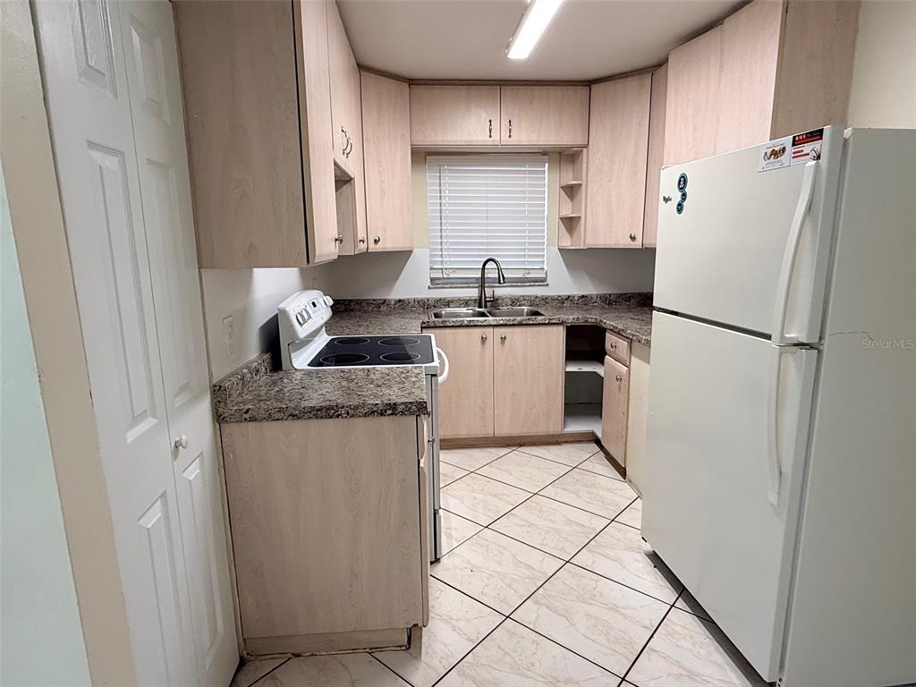 3704 36th Street West Bradenton, FL 34205 - Photo 6 of 34 a kitchen with a refrigerator sink stove and cabinets
