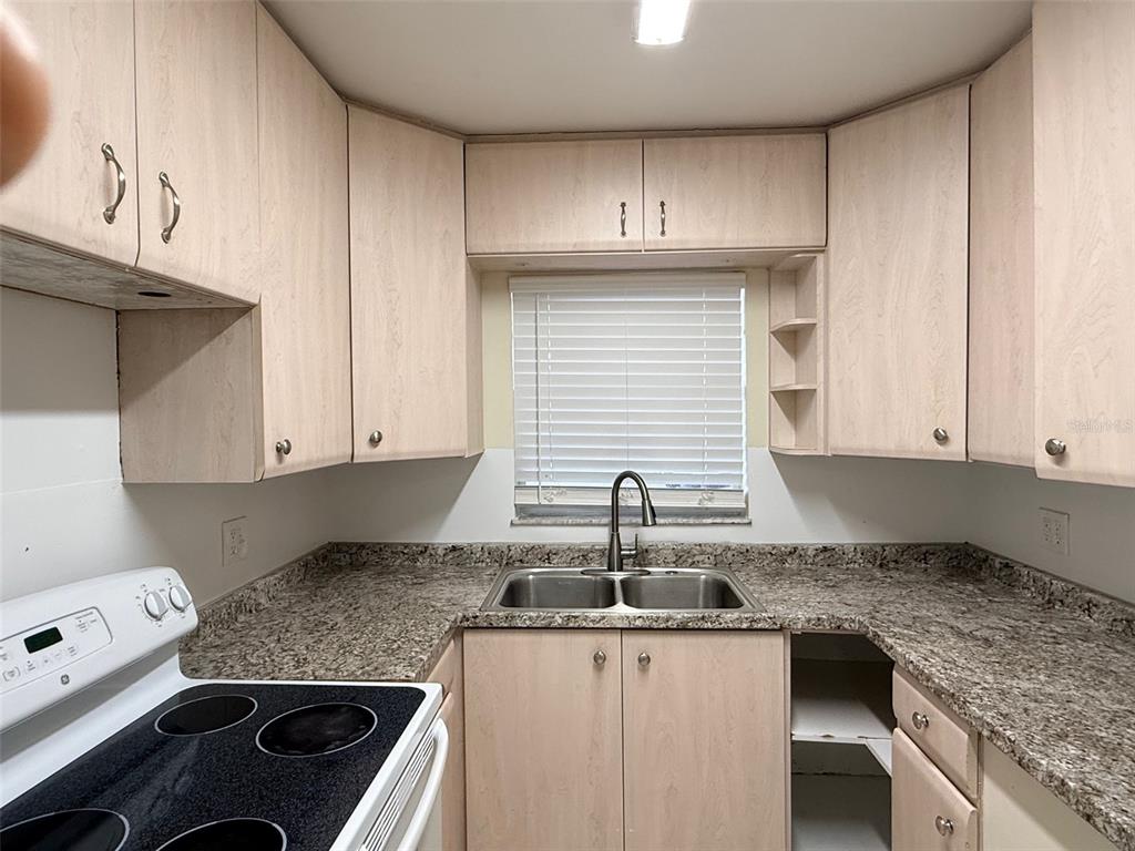 3704 36th Street West Bradenton, FL 34205 - Photo 7 of 34 a kitchen with stainless steel appliances granite countertop a sink stove and cabinets