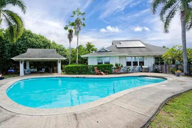 a view of a house with swimming pool and sitting area