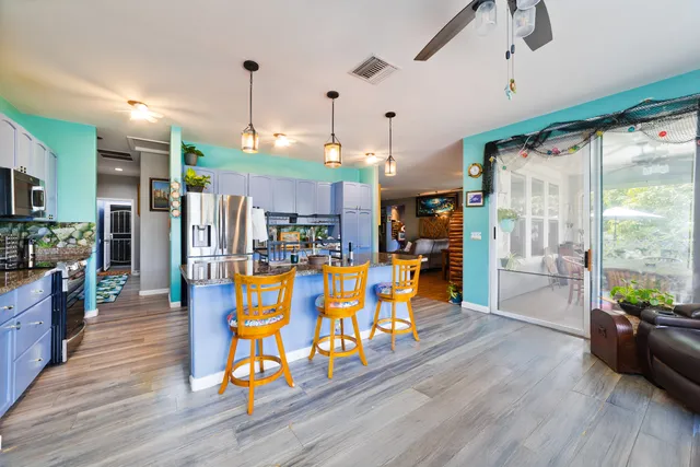 a view of a living room and kitchen with furniture wooden floor and a window