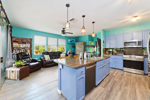 a kitchen with stainless steel appliances granite countertop sink stove top oven and cabinets