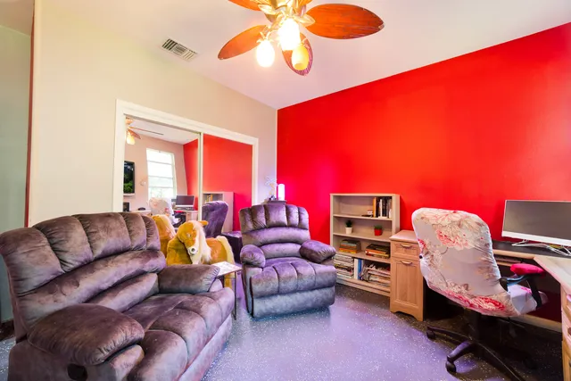 a living room with furniture a ceiling fan and a window