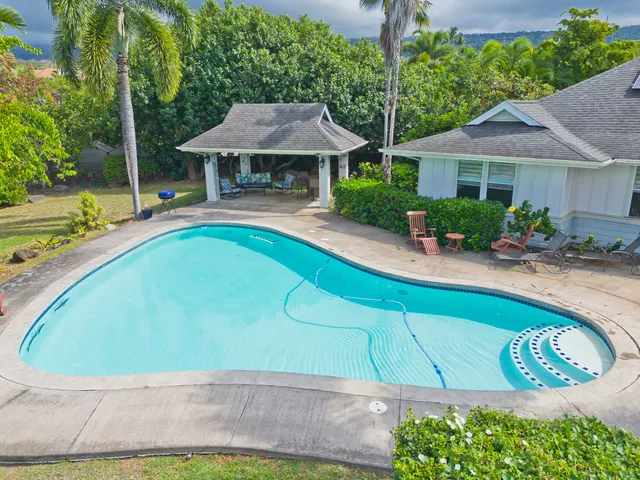 a view of a house with pool and chairs
