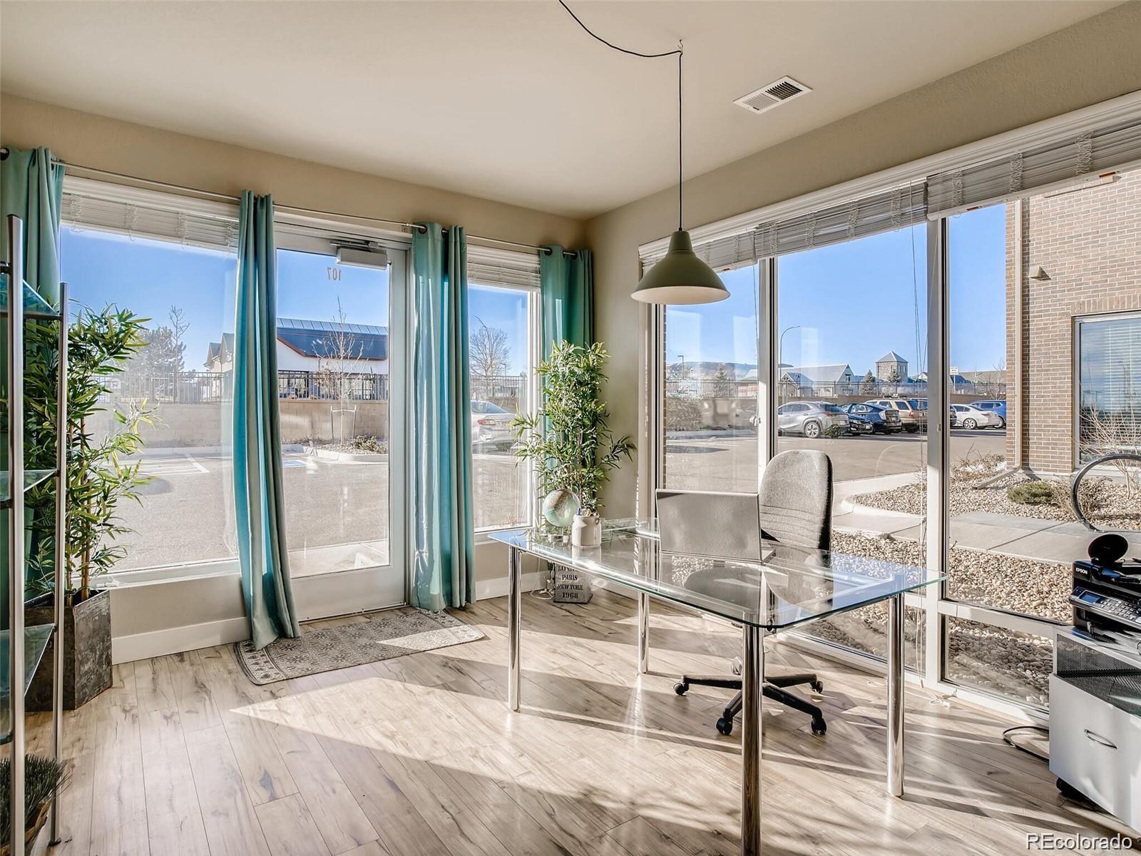15274 West 64th Lane, Unit 107 Arvada, CO 80007 - Photo 1 of 24 a view of a room with a large window and wooden floor