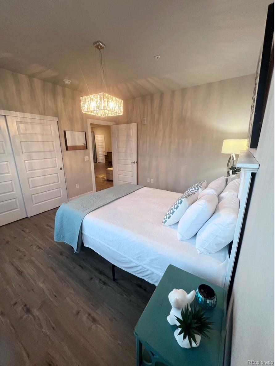 15274 West 64th Lane, Unit 107 Arvada, CO 80007 - Photo 9 of 24 a bedroom with a bed and a chandelier