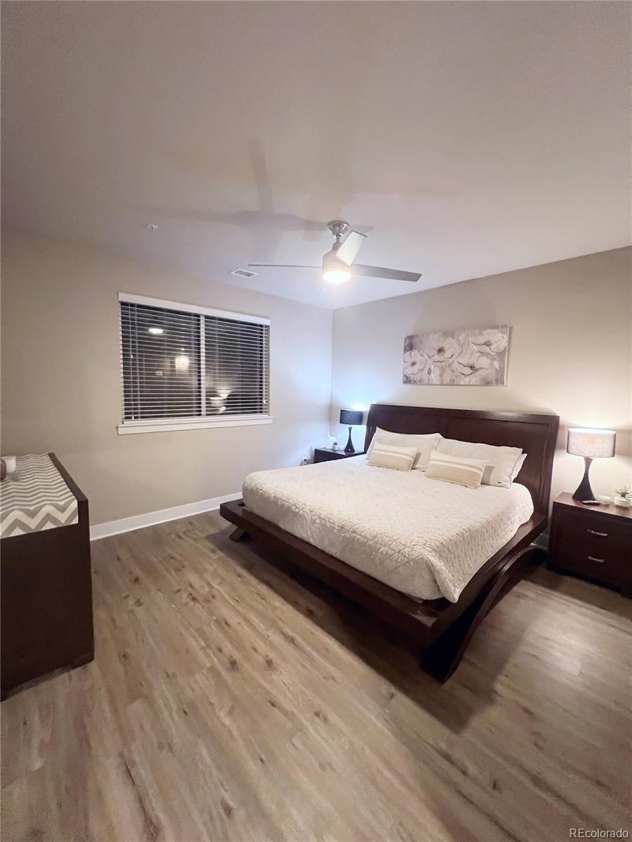 15274 West 64th Lane, Unit 107 Arvada, CO 80007 - Photo 10 of 24 a spacious bedroom with a bed and wooden floor