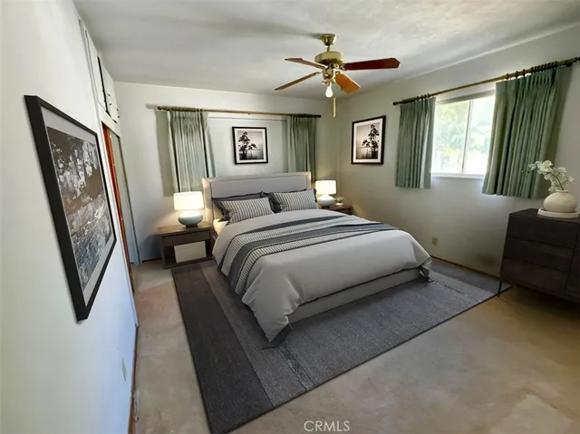 a bedroom with a large bed couch and windows