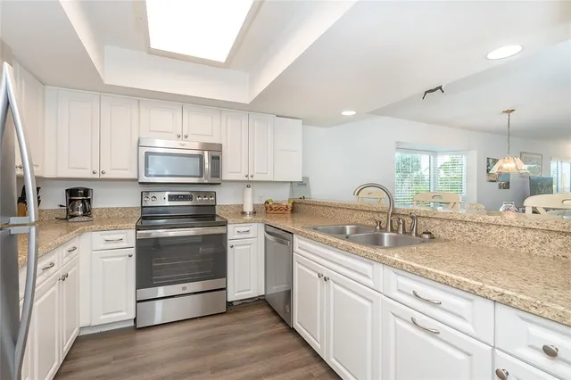 a kitchen with a sink stove and white cabinets