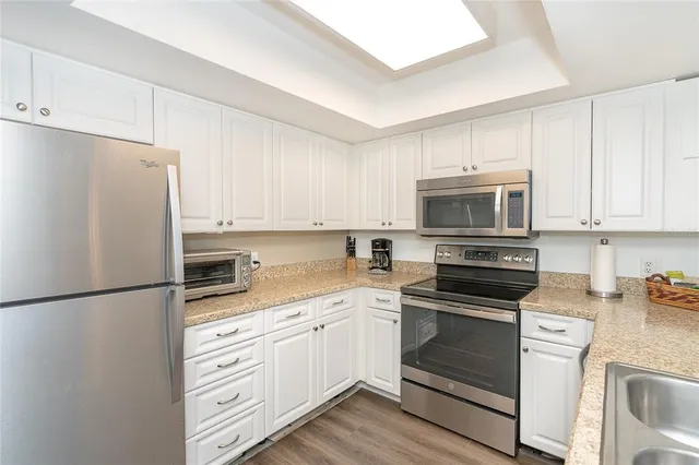 a kitchen with white cabinets and stainless steel appliances