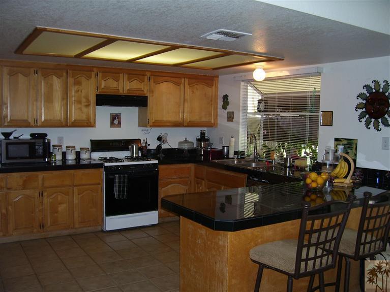 68325 Encinitas Road Cathedral City, CA 92234 - Photo 8 of 20 a kitchen with stainless steel appliances granite countertop a sink and a refrigerator